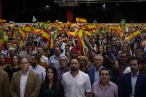 Santiago Abascal junto a Manuel Mestre y Ana Vega escuchando el himno de España con el abarrotado IFA de fondo / Santiago Abascal