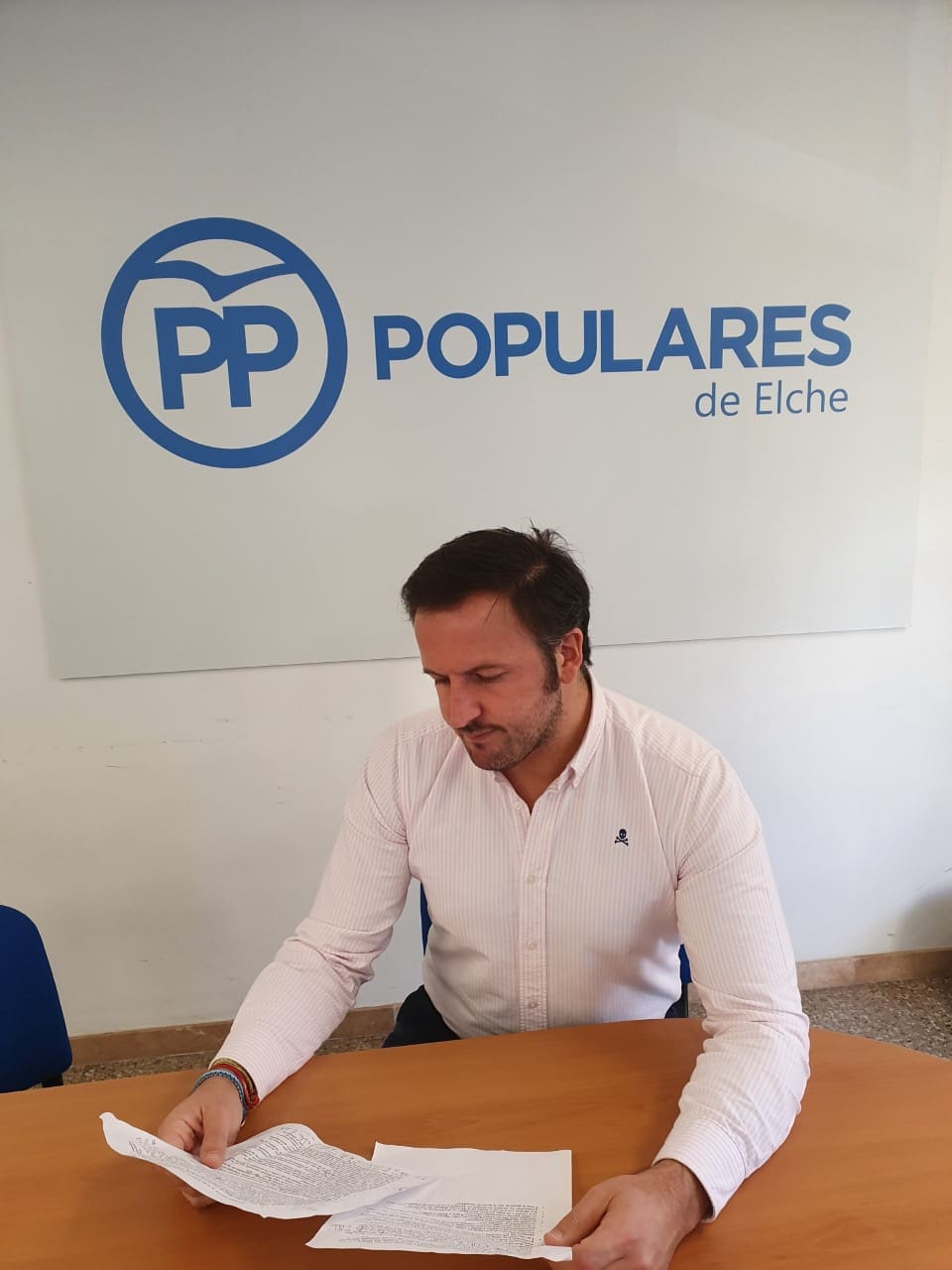 Pablo Ruz leyendo dos documentos en la sede del PP de Elche / Alex Ferrer