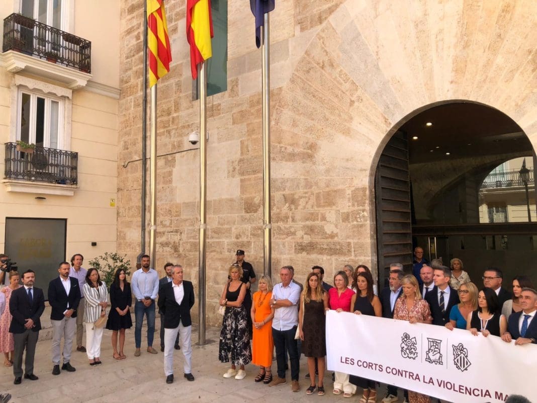 Momento en el que la presidenta de las Corts se apartó de la pancarta contra la violencia machista