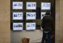 Alicante bate récords de empleo, pero la vivienda y los bajos salarios frenan el bienestar Persona pasa ante anuncios de venta y alquiler en una inmobiliaria de València