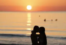 Pareja se abraza al amanecer en la playa de la Malvarrosa