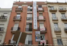 Manifestación por el derecho a la vivienda en Valencia con pancarta bajo el lema “Acabem amb el negoci de l’habitatge”.