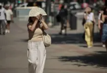 Mujer se protege del calor con un abanico en una imagen de archivo