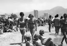 Turistas pasean y descansan en la playa de Benidorm en 1966