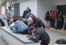 Inmigrantes realizando trámites de regularización, ante documentación y formulario