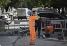 Varias personas se protegen del calor con paraguas en la calle.