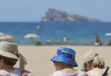 Tres personas contemplan la playa de Benidorm (Alicante) en una imagen de archivo.