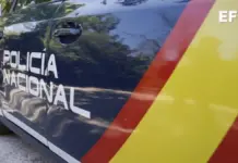 Agente de policía junto a un aviso falso relacionado con un corte de luz por impago