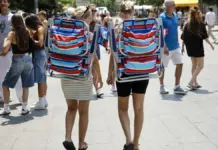 La Comunitat Valenciana alcanza los 6 millones de turistas extranjeros hasta junio y bate récord de gasto Dos turistas pasean por el centro de València con sillas de playa
