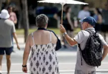 Personas protegiéndose del sol en València