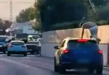 Coche con una persona subida en el techo, en Xàbia (Alicante).