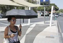 El calor vuelve a apretar en la Comunitat Valenciana con 37 grados en Pego Mujer protegida con un paraguas del intenso sol en una imagen de archivo
