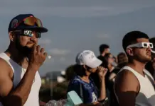 Personas reunidas en el exterior del aeropuerto de Manises (Valencia) para observar un eclipse solar