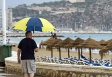 Hombre con paraguas camina por el paseo marítimo de Calpe durante la lluvia