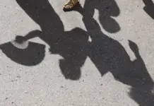 Una viandante protege del sol su rostro con un abanico en una jornada calurosa de septiembre.