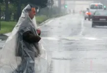Lluvias torrenciales activan el aviso naranja en Alicante y Valencia este jueves Hombre protegido con plásticos ante una fuerte lluvia.