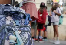 Escena de inicio del curso escolar, con personal y entorno escolar al fondo