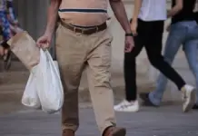 Hombre caminando por una calle de València con bolsas de la compra
