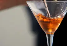 Barman preparando un cóctel en un certamen en València con ingredientes tipo ron y vermut