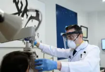 Tres de cada cuatro menores en la Comunitat presentan algún problema de visión Optometrista revisando la vista a un hombre en una consulta.
