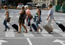 Turistas arrastrando maletas tras abandonar un hotel en València