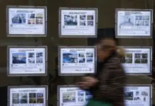 La compra de vivienda por extranjeros se desploma un 15,4 % en la Comunitat Valenciana Persona pasa ante anuncios de venta y alquiler en una inmobiliaria de València