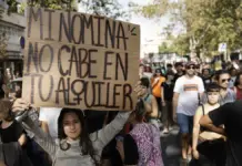 Una experta de la UA defiende limitar el alza del alquiler de forma temporal Personas en una manifestación con pancartas contra la especulación y los precios del alquiler
