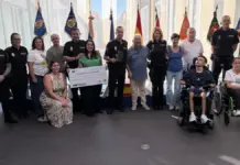 Cheque de la carrera Ruta 091 entregado a AEBHA con el comisario jefe provincial Pedro Montore presente.