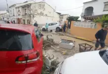 Calle con destrozos tras inundaciones en Els Poblets, con agua y arrastre visible