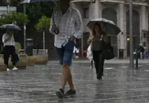Una dana dejará lluvias muy intensas en el Mediterráneo y bajada de temperaturas Personas caminando bajo la lluvia en una calle de Palma, Baleares.